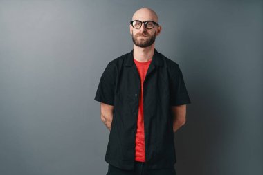 Gri arka plan üzerinde stüdyoda poz şık genç adam