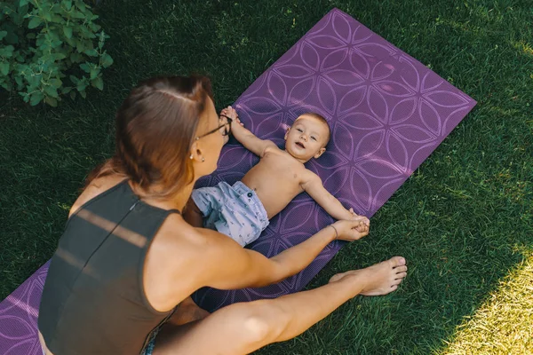 Mãe fazendo ioga bebê para seu filho — Fotografia de Stock