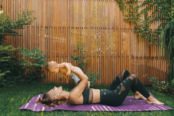 Madre haciendo yoga de bebé para su hijo — Foto de Stock