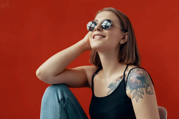 Jeune fille assise sur une chaise blanche près du mur rouge — Photo