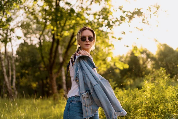 Een vrouw met een zonnebril die in het park loopt — Stockfoto