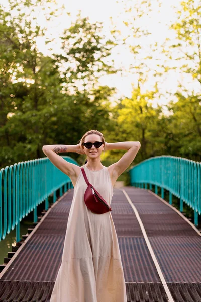 Femme insouciante dans une robe marchant sur le pont — Photo