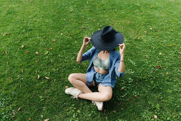 青い縞模様のジャケットと黒の帽子を身に着けている若い女の子のファッションの肖像画 — ストック写真