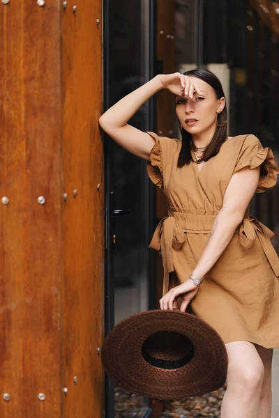 Junges Modemädchen im Sommerkleid mit breitem Korbhut spaziert und posiert in der Altstadt — Stockfoto