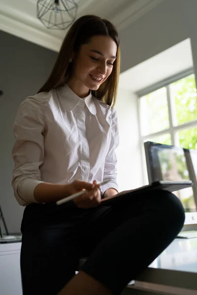 Mujer joven sosteniendo una tableta digital en las manos — Foto de Stock