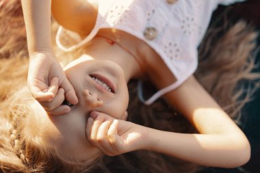 Doğada battaniyeye uzanmış sevimli küçük bir kız.