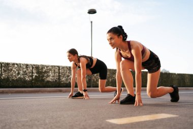 Kadın koşucular koşmaya ve birbirleriyle yarışmaya hazır.