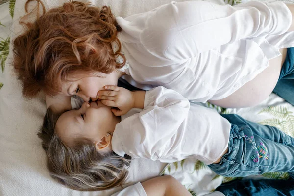 Madre e hija embarazadas tumbadas en la cama —  Fotos de Stock