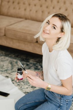 Resim yaparken poz veren gülümseyen kadın