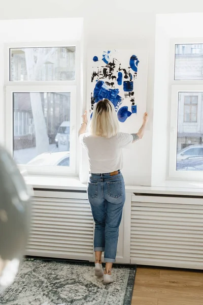 Jonge vrouw plaatst abstracte verf op de muur — Stockfoto