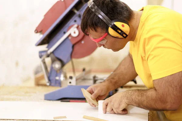 Timmerman maakt een meubelstuk in een werkplaats — Stockfoto