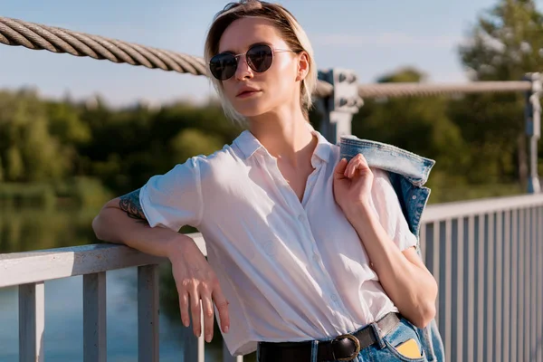 Mulher na moda em óculos de sol em relaxar em uma ponte — Fotografia de Stock