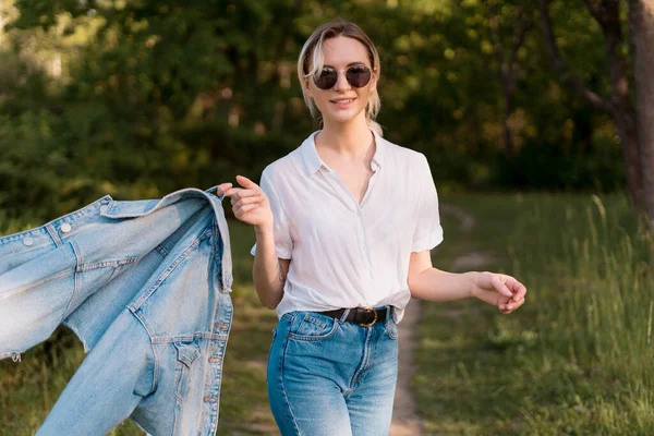 Een vrouw met een zonnebril die in het park loopt — Stockfoto
