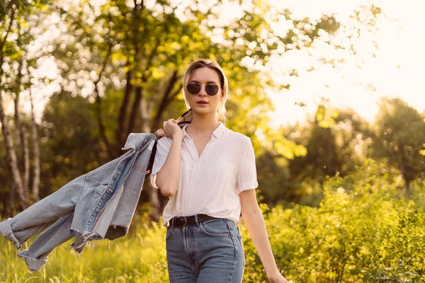 Een vrouw met een zonnebril die in het park loopt — Stockfoto