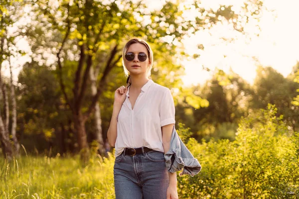 Frau mit Sonnenbrille spaziert im Park — Stockfoto