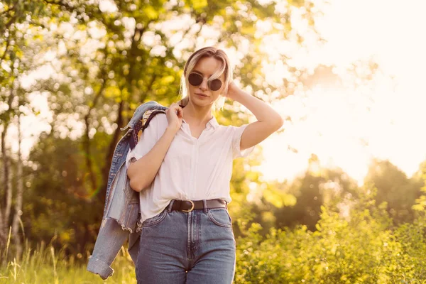 Een vrouw met een zonnebril die in het park loopt — Stockfoto