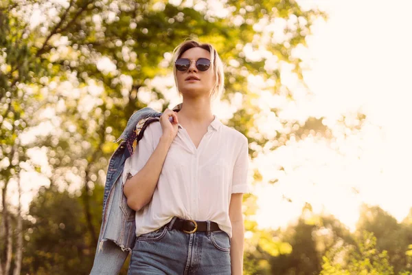 Жінка в сонцезахисних окулярах, що ходять в парку — стокове фото