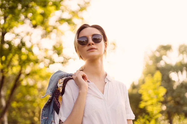 Een vrouw met een zonnebril die in het park loopt — Stockfoto