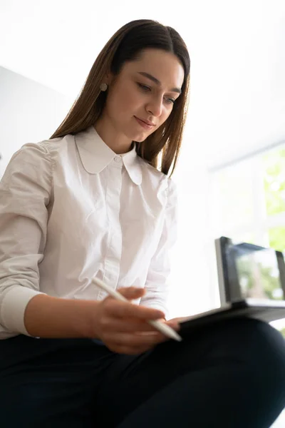 Mujer joven sosteniendo una tableta digital en las manos — Foto de Stock