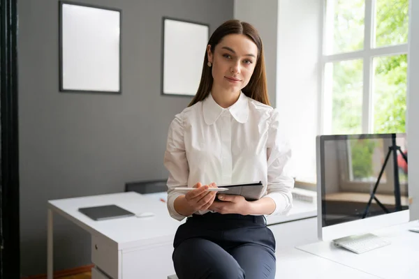 Mujer joven sosteniendo una tableta digital en las manos — Foto de Stock