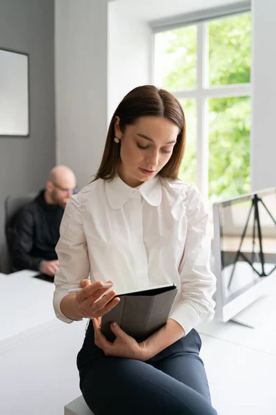 Mujer joven sosteniendo una tableta digital en las manos — Foto de Stock