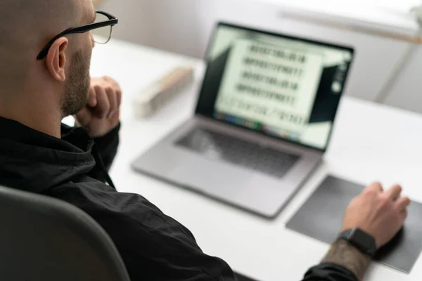 Retrato del joven sentado en su escritorio en la oficina en el portátil — Foto de Stock