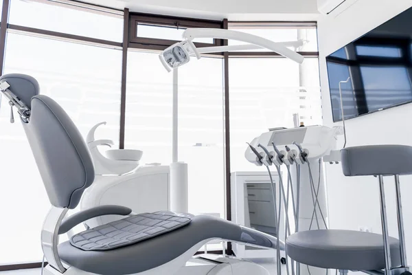 Cadeira dentária e outros acessórios durante a prática odontológica moderna — Fotografia de Stock