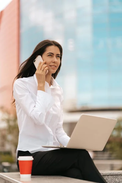 Millennial businesswoman mluví na telefonu venku — Stock fotografie