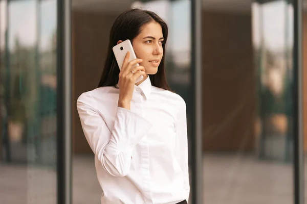 Krásná žena mluví po telefonu v blízkosti obchodní budovy — Stock fotografie