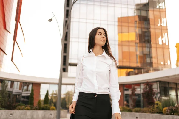 Krásná žena v bílé košili na obchodní budovy pozadí — Stock fotografie
