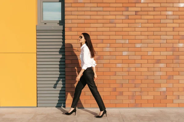 Hermosa mujer con gafas de sol caminando por la calle urbana —  Fotos de Stock