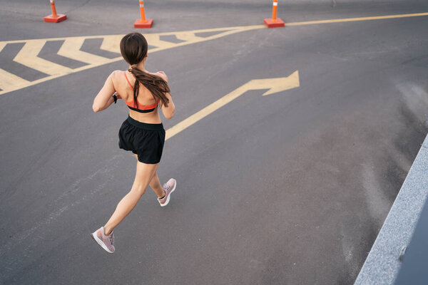 Female fitness model training outside in the city