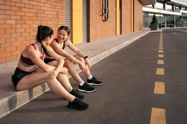 两名年轻美丽的女运动员在城市锻炼后休息的画像 — 图库照片