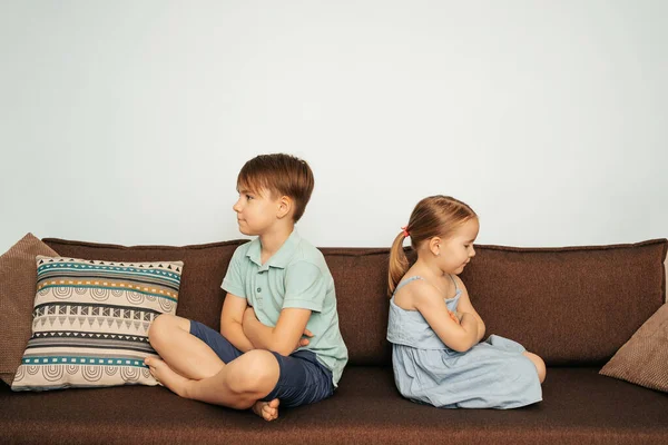 Pojke och flicka sitter upprörda på soffan — Stockfoto