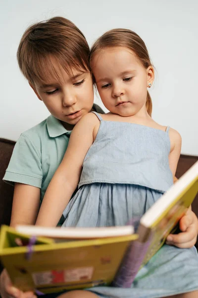 Broer leert zijn zusje lezen — Stockfoto