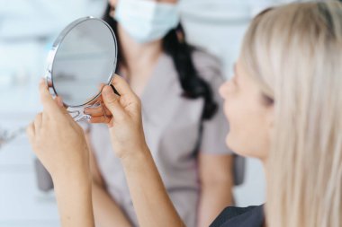 Hasta tedaviden sonra aynada gülümsemesine bakıyor..