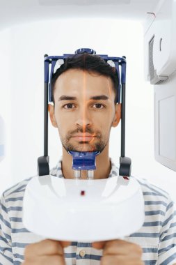 Young man in a dental 3D scanner clipart