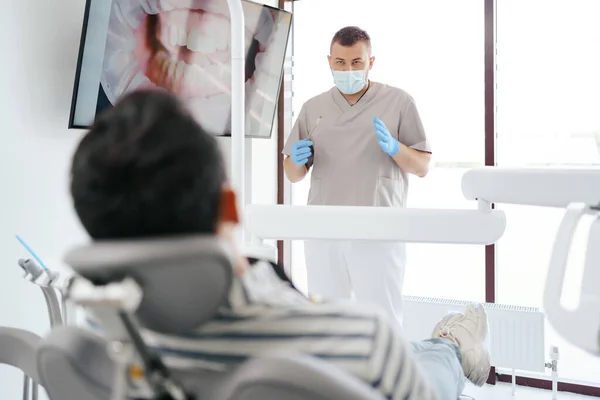 Dentista explicando a imagem dos dentes na tela — Fotografia de Stock