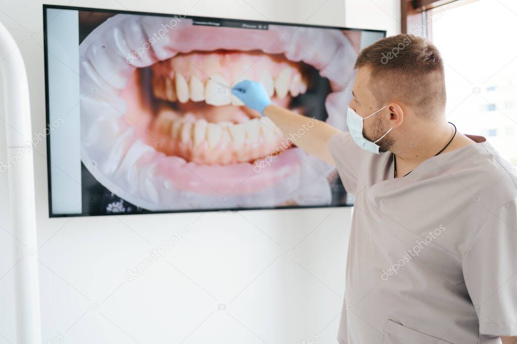 Doctor dentist showing patients teeth