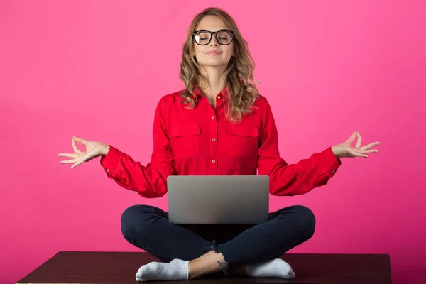 kırmızı bir gömlek kırmızı arka plan üstünde a laptop yanında oturan gözlüklü güzel genç kız