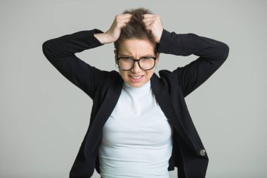 Genç güzel kız ile bir kısa saç kesimi ciddi bir yüz ifadesi ile gri bir arka plan üzerinde siyah ceket