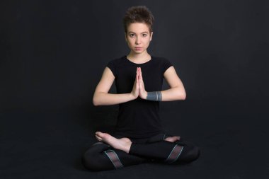 siyah t-shirt bir yoga poz kısa bir saç kesimi ile güzel genç kız