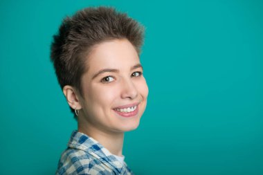 mavi bir arka plan üzerinde bir gömlek kısa saçlı güzel genç kız