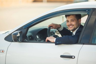 Yaz aylarında arabada oturan takım elbiseli yakışıklı genç