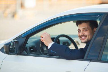 yakışıklı genç bir araba anahtarı ile yaz aylarında arabada oturan bir takım