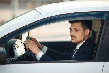 Yaz aylarında arabada oturan takım elbiseli yakışıklı genç