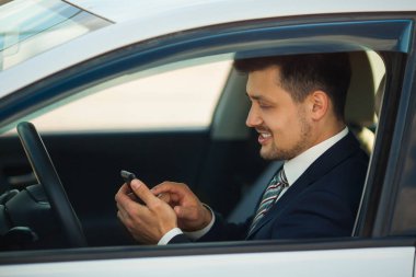 telefonda arabada oturan bir uymak yakışıklı genç adam