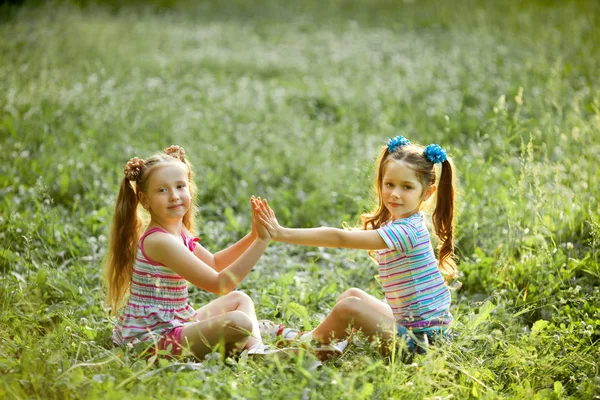 Yeşil Yaz Çimen Parkta Oturup Oynayan Iki Güzel Kızın — Stok fotoğraf