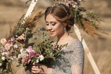 güzel genç kız makyaj ve saç modeli ayakta yaz aylarında bir buket çiçek ile bir dekora yakınındaki bir alana