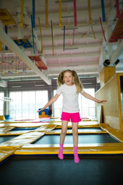 güzel küçük kız oyun bir kulüpte bir trambolin üzerinde atlama